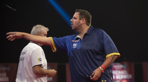 Der Dart von Adrian Lewis fliegt bereits durch die Luft, während sein Gegner noch zurückläuft