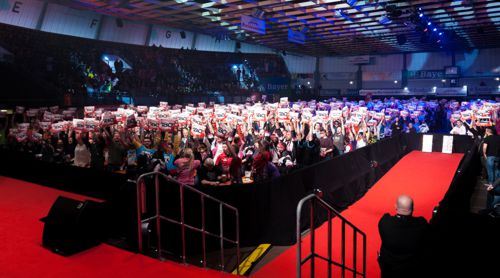 Die Dartfans in der Ostermann-Arena halten ihre 180er Schilder hoch