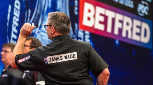 James Wade vor dem Logo des Sponsors Betfred
