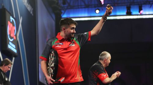 Jamie Lewis spaziert mit dem unterschriebenen Dartboard von der Bühne des Alexandra Palace