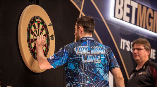 Luke Humphries zieht seine Darts aus dem Dartboard