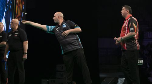 Mensur Suljovic sieht Rob Cross beim Wurf zu