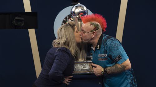 Peter Wright küsst seine Frau vor dem Pokal des Weltmeisters