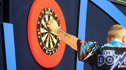 Phil Taylor zieht die Darts aus dem Dartboard